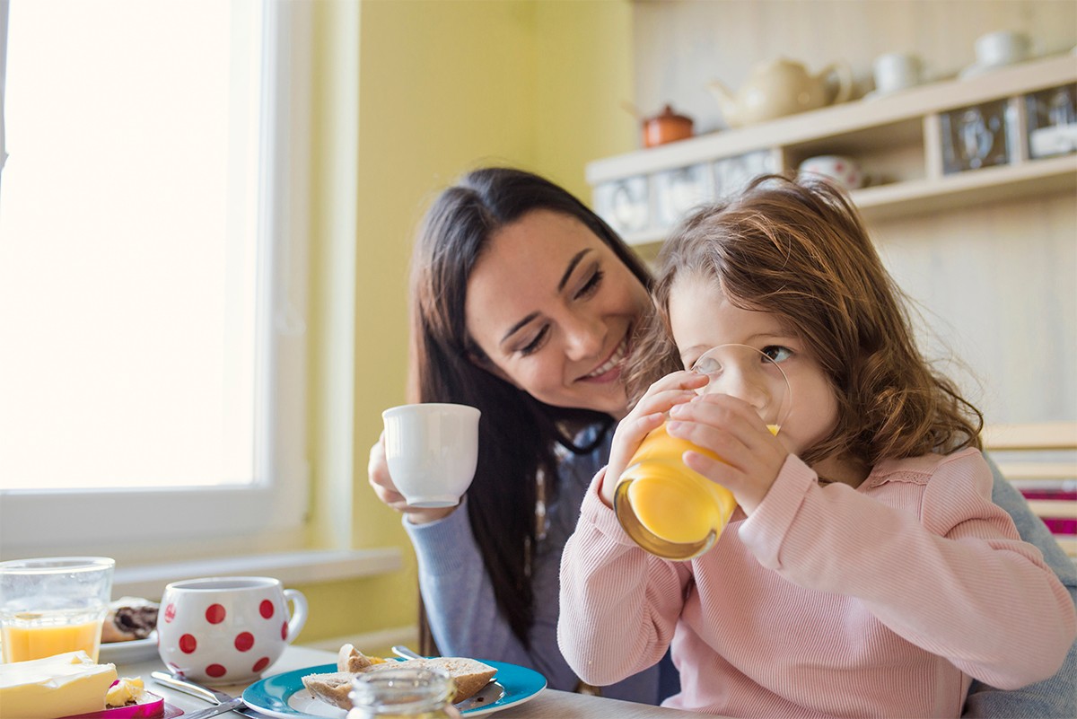 mama-nina-desayuno-nutritivo Mamá e hija disfrutando un desayuno nutritivo para comenzar el día con energía.